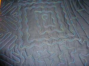 The back of a T-shirt quilt with the quilting showing because a solid color was used.